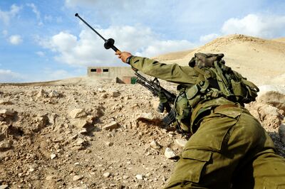 照片中的士兵正在给步枪装上一发以色列造SIMON破门枪榴弹，它属于套管式枪榴弹，带有弹头捕获装置，因此无需使用空包弹发射。破门枪榴弹是罕见的弹药，出产这种弹药的国家并不多。