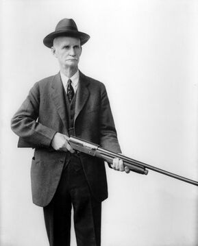美國發明家、自動武器宗師——約翰·摩西·白朗寧和他的Auto-5霰彈槍合影。Auto-5是世界上第一種實用型的半自動霰彈槍，在一戰、二戰和越戰等重大戰役中充分證明了它的價值。